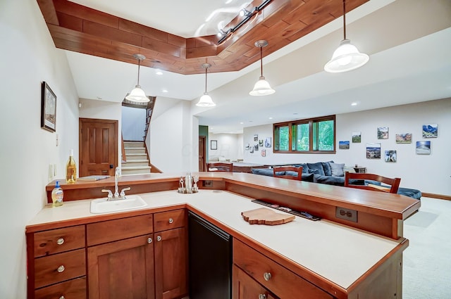 kitchen featuring open floor plan, dishwasher, carpet floors, hanging light fixtures, and a sink