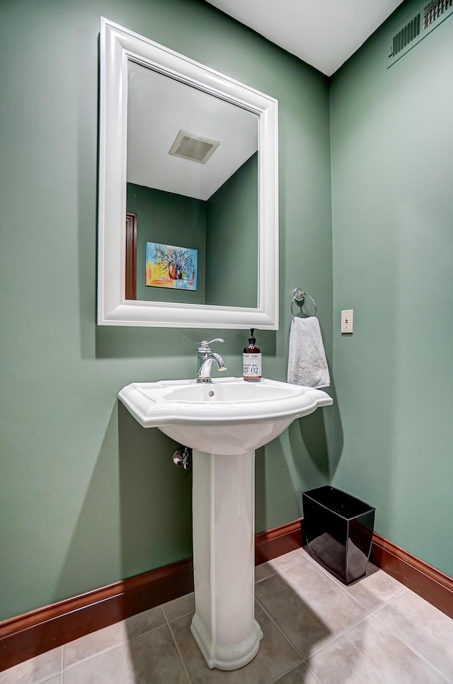 bathroom featuring tile patterned floors, visible vents, baseboards, and a sink