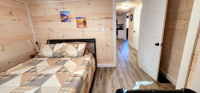 bedroom featuring wooden walls, a fireplace, and wood finished floors