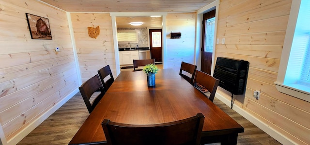 dining area featuring dark wood finished floors, wood ceiling, and wood walls