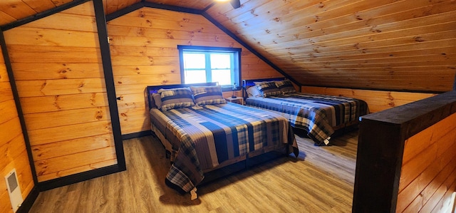 bedroom with lofted ceiling, wood ceiling, light wood-style flooring, and wood walls