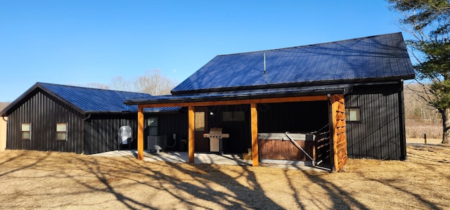 exterior space with central AC unit, metal roof, and an outdoor structure