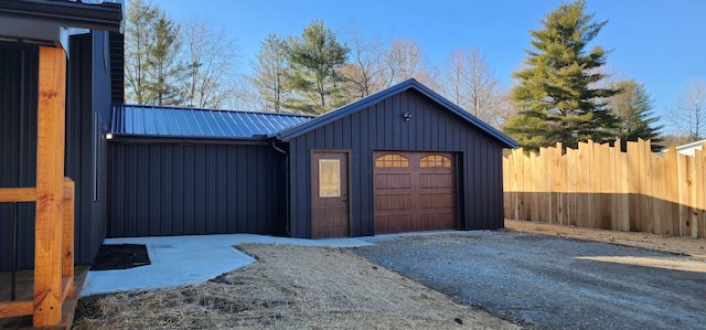 garage featuring driveway and fence