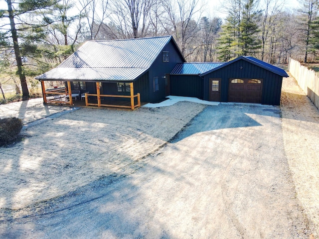 chalet / cabin with fence, a garage, driveway, and metal roof