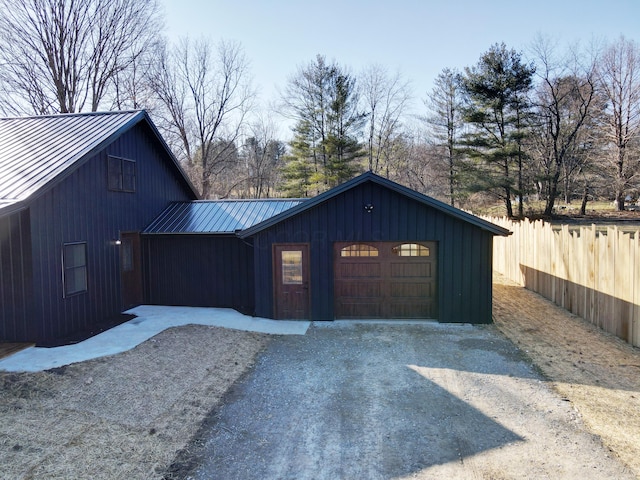 garage featuring driveway and fence