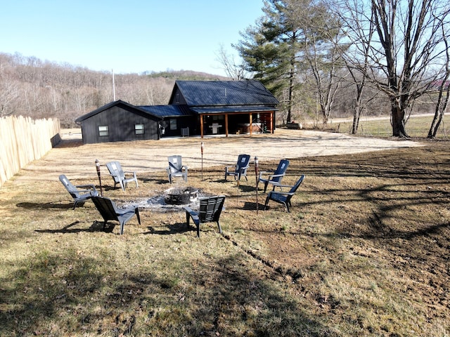 view of yard with fence and an outdoor fire pit