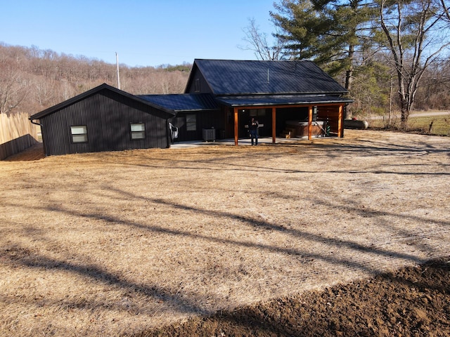 back of property with cooling unit and metal roof