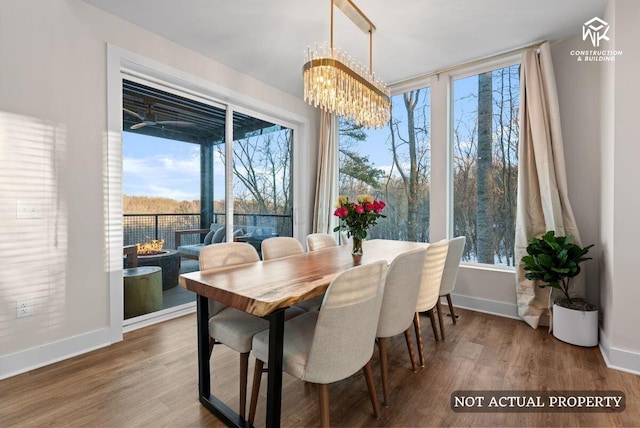 dining space featuring a wealth of natural light, a chandelier, and wood finished floors