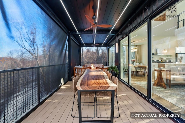 deck with a fire pit and ceiling fan