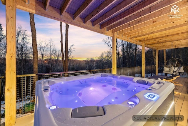 deck at dusk with a hot tub