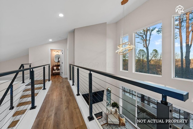 hall with a chandelier, lofted ceiling, an upstairs landing, recessed lighting, and wood finished floors