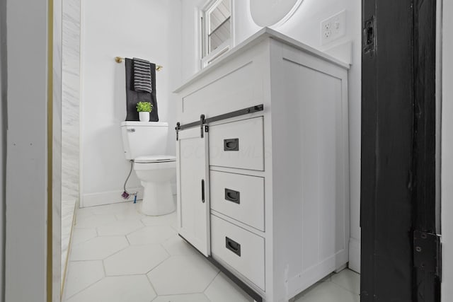 bathroom with tile patterned flooring, toilet, and baseboards