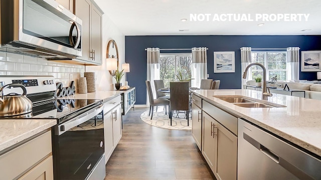 kitchen with a sink, plenty of natural light, appliances with stainless steel finishes, and dark wood-style flooring