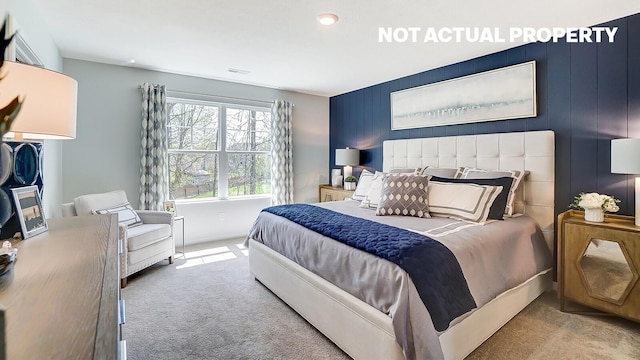 carpeted bedroom featuring visible vents and an accent wall