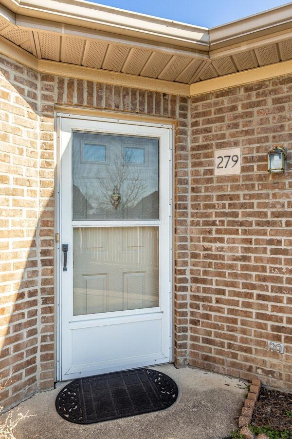 doorway to property with brick siding