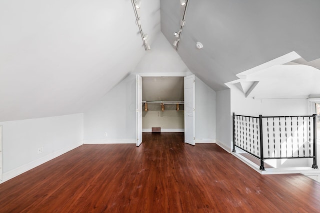 bonus room featuring baseboards, wood finished floors, and vaulted ceiling