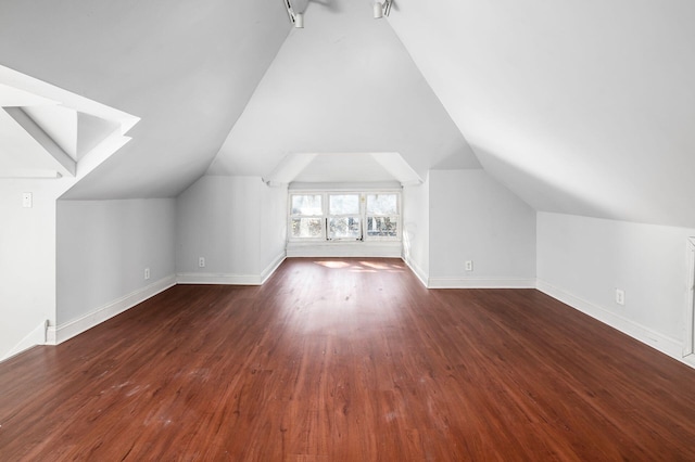 additional living space featuring baseboards, lofted ceiling, and wood finished floors