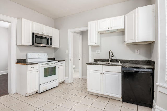 kitchen featuring white electric range, stainless steel microwave, a sink, black dishwasher, and dark countertops