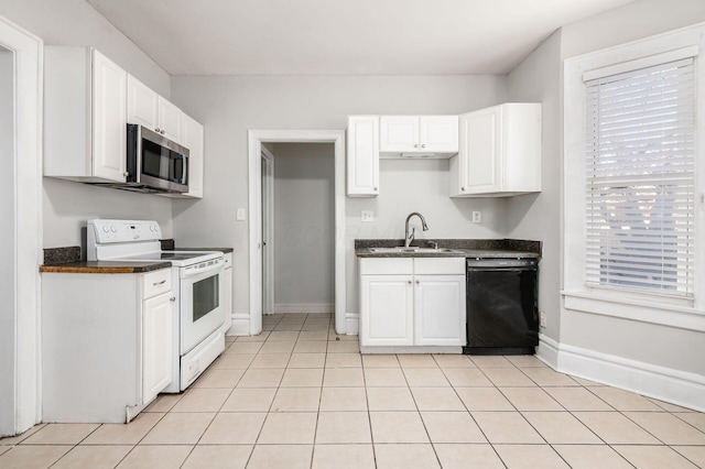 kitchen featuring dark countertops, white electric stove, a sink, dishwasher, and stainless steel microwave