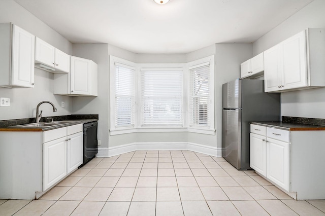 kitchen featuring a sink, black dishwasher, a wealth of natural light, and freestanding refrigerator