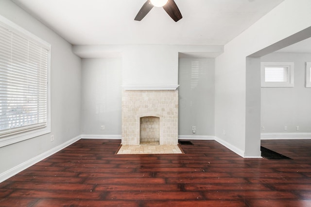 unfurnished living room with a healthy amount of sunlight, wood finished floors, and a fireplace