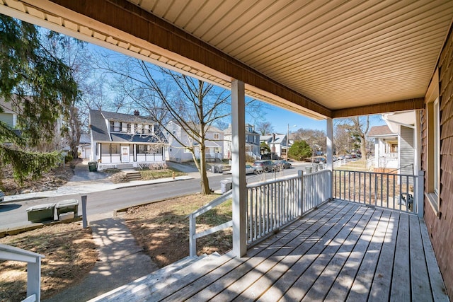 wooden deck with a residential view and covered porch