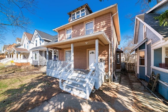 traditional style home featuring fence, covered porch, and a residential view