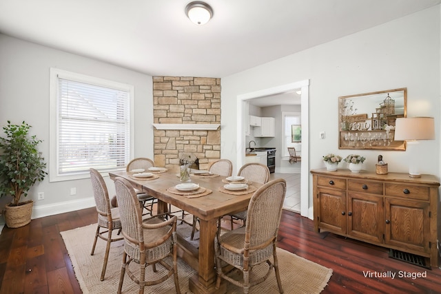 dining space with a wealth of natural light, baseboards, and dark wood finished floors