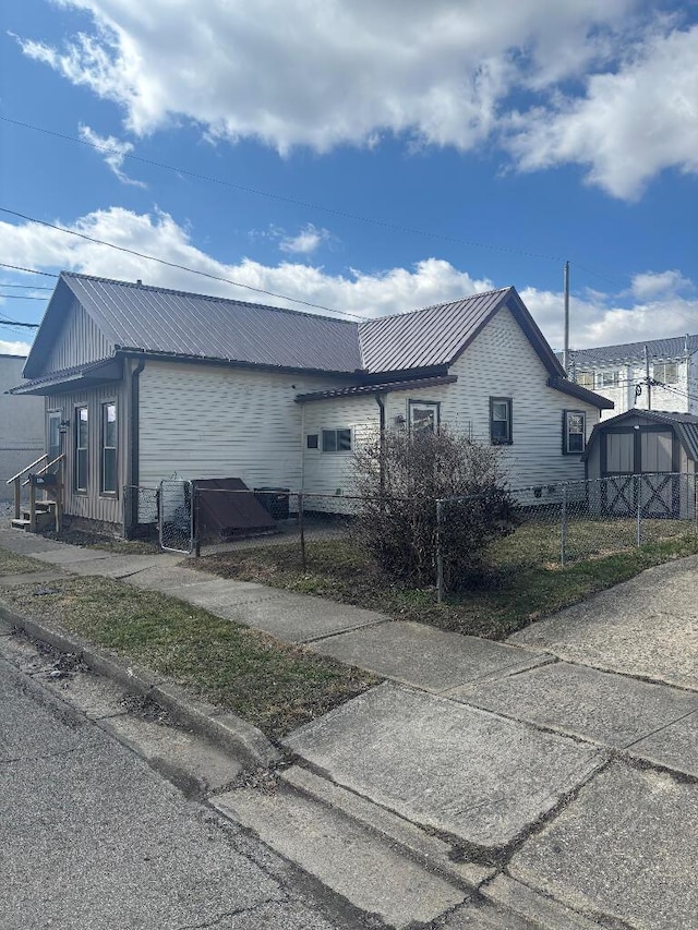 view of property exterior featuring metal roof and fence