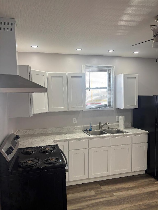 kitchen with black appliances, a sink, dark wood finished floors, white cabinets, and extractor fan