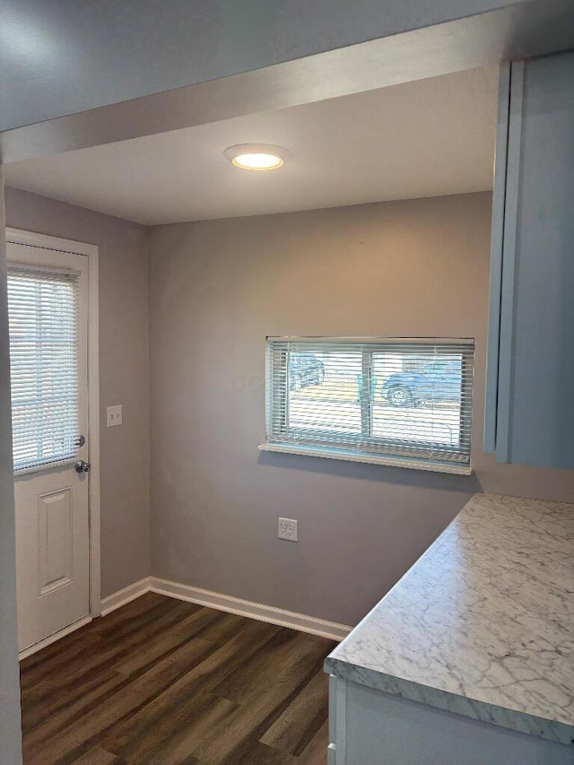 interior space with dark wood finished floors, light countertops, and baseboards