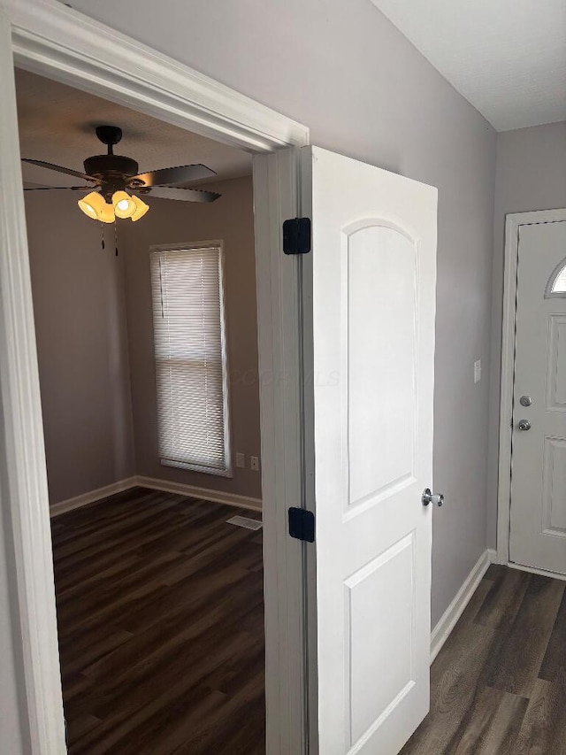 interior space with baseboards and dark wood-style floors