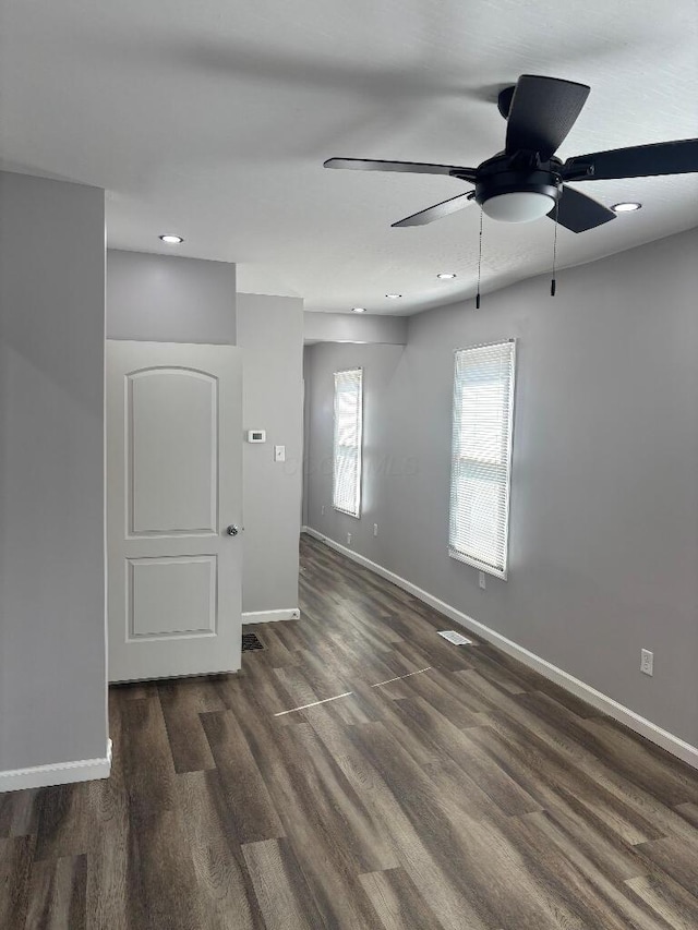 empty room with a ceiling fan, recessed lighting, wood finished floors, and baseboards