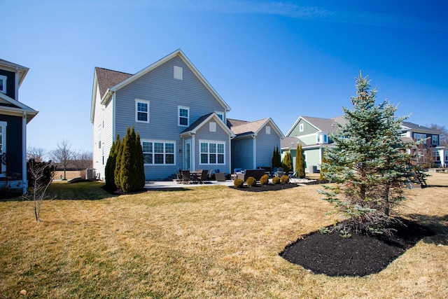 back of house with a patio area and a lawn