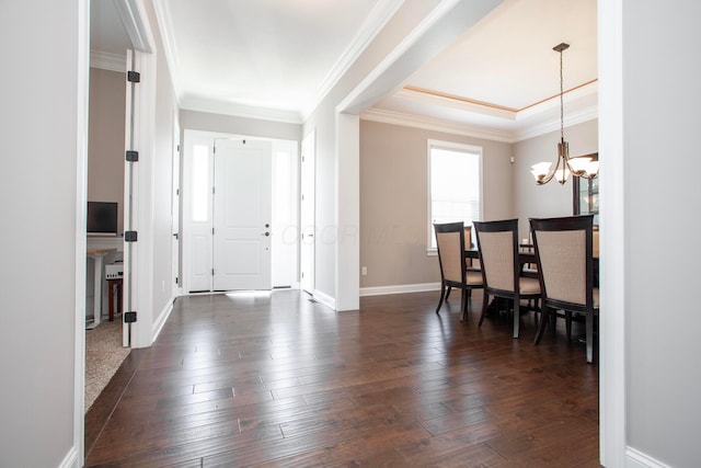 entrance foyer featuring dark wood-style floors, baseboards, crown molding, and an inviting chandelier