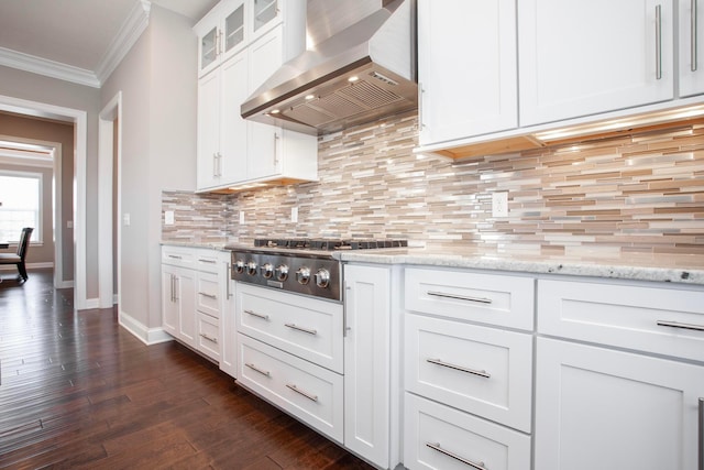 kitchen with white cabinets, wall chimney exhaust hood, crown molding, decorative backsplash, and stainless steel gas cooktop