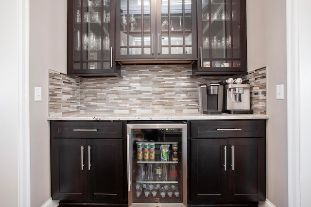 bar with wine cooler, decorative backsplash, and a dry bar