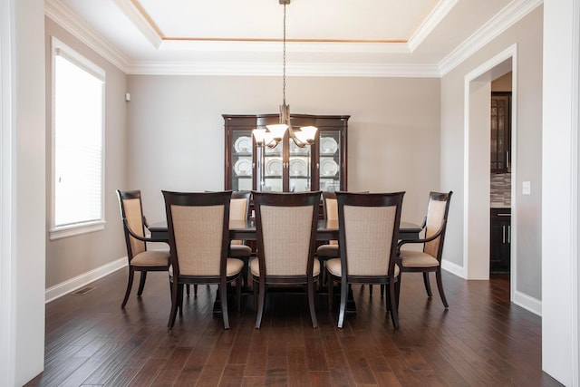 dining space with baseboards, visible vents, dark wood-style flooring, crown molding, and a notable chandelier