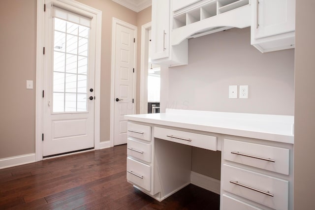 kitchen with dark wood-style floors, baseboards, light countertops, white cabinets, and crown molding