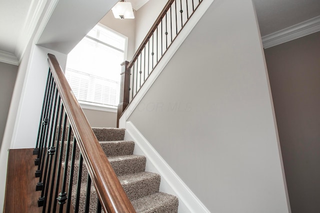 staircase featuring baseboards and ornamental molding