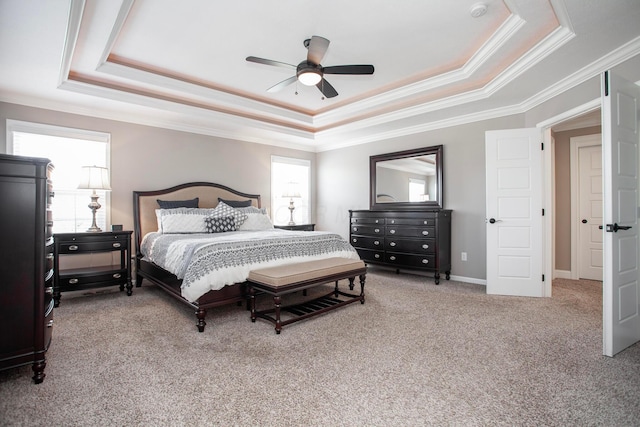 bedroom with ornamental molding, baseboards, a tray ceiling, and carpet floors