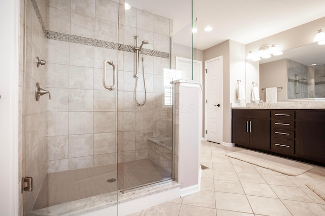 bathroom with baseboards, a stall shower, vanity, and tile patterned flooring