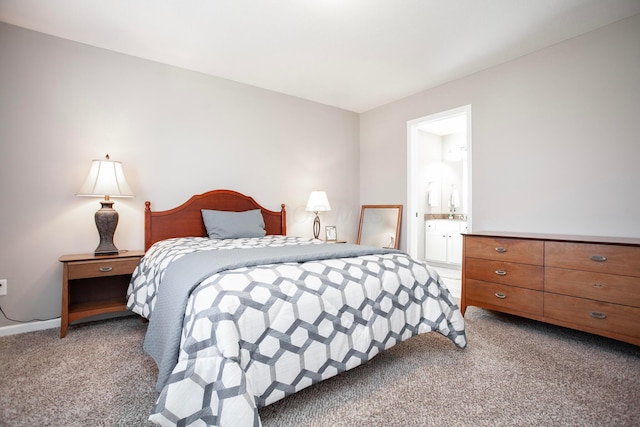 bedroom with ensuite bath and light colored carpet