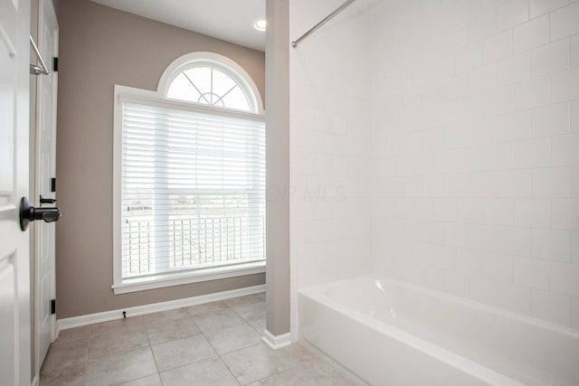 bathroom with tile patterned floors, baseboards, and  shower combination