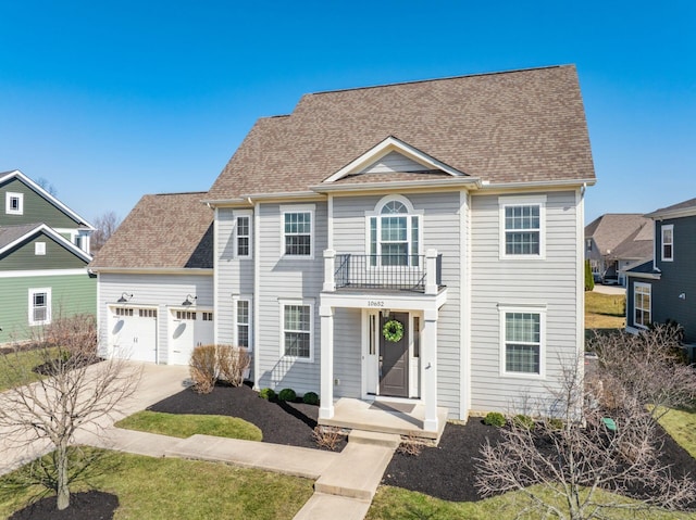 view of front of house featuring a balcony, roof with shingles, concrete driveway, and an attached garage