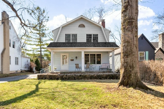 dutch colonial with a gambrel roof, a porch, a front yard, a shingled roof, and a chimney