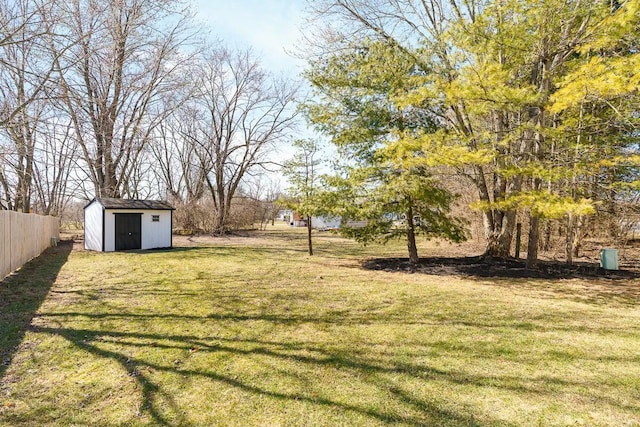 view of yard with an outbuilding, a storage shed, and fence