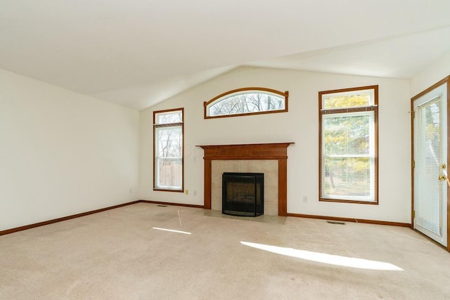 unfurnished living room with lofted ceiling, carpet flooring, a fireplace, and baseboards