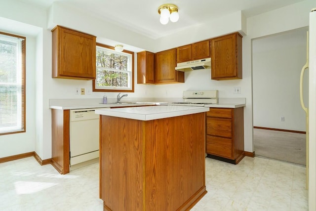 kitchen with white appliances, light floors, under cabinet range hood, and light countertops