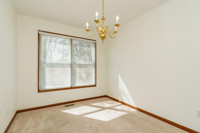 empty room with baseboards, carpet floors, an inviting chandelier, and visible vents